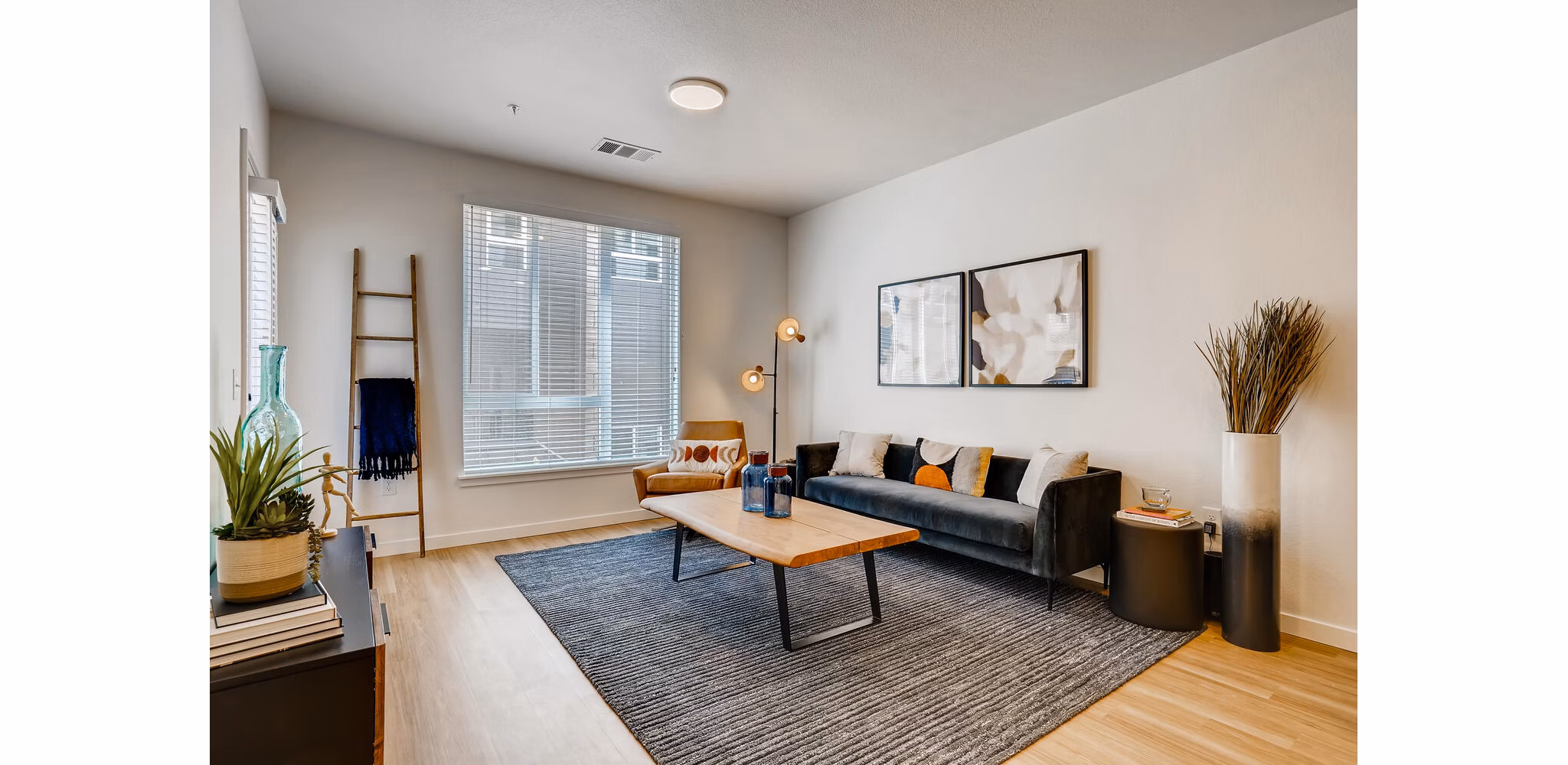 Spacious living room with modern decor and large windows at Legacy at Fitz Apartments