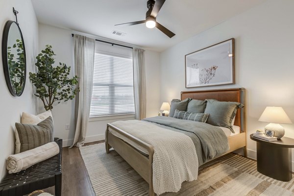 Spacious bedroom featuring modern decor and abundant natural light at The Grayson Apartments