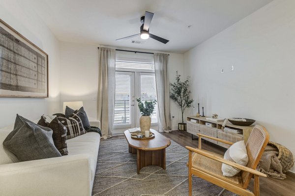 Cozy living room with modern decor and large windows in The Grayson Apartments