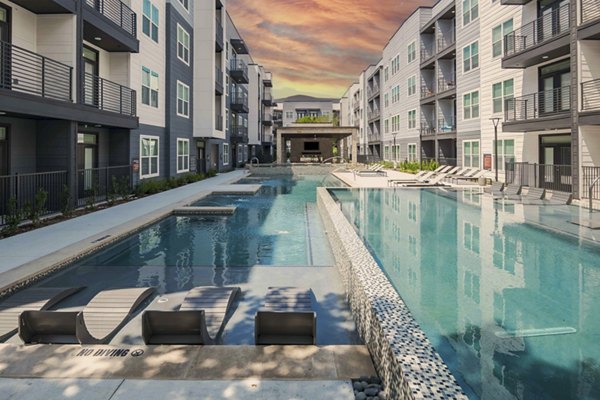 Pool with sundeck at Bay Court at Harbour Pointe Apartments, offering resort-style luxury living in a serene community setting