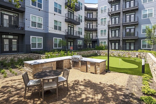 Outdoor grill area with modern seating at The Grayson Apartments, luxury living in a vibrant setting