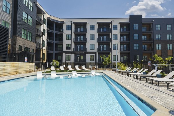Large outdoor pool with lounge chairs at Bowery West Apartments offering luxury amenities