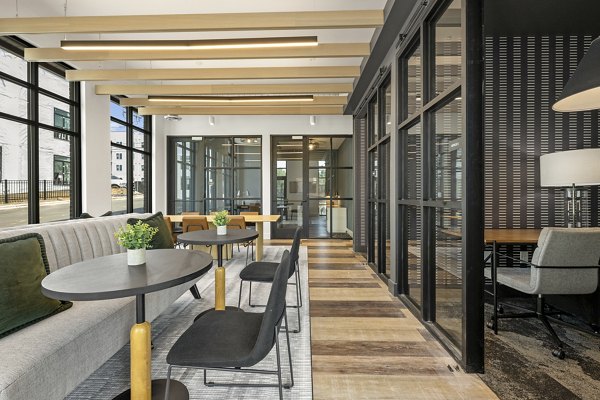 Modern office lounge area with tables, chairs, and plants in luxury apartments