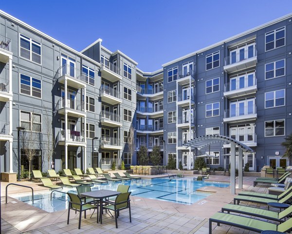 Modern outdoor pool at 1377 Apartments featuring lounge seating and city views