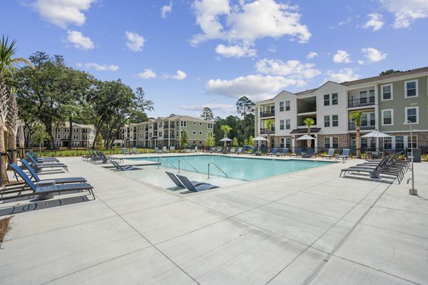 Luxurious swimming pool area at 4000 Margaret Apartments, featuring elegant lounge seating and scenic views for upscale relaxation