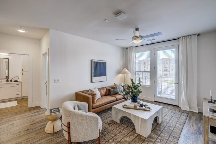 Spacious living room with modern decor and ample natural light in The Taylor at Greenway Apartments