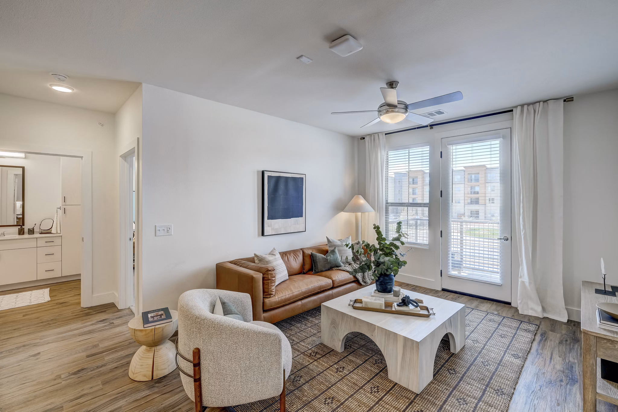 Spacious living room with modern decor and ample natural light in The Taylor at Greenway Apartments