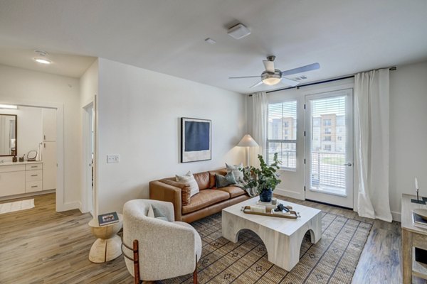 Spacious living room with modern decor and ample natural light in The Taylor at Greenway Apartments