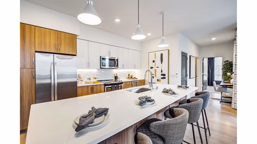 Contemporary kitchen with sleek appliances and marble countertops at The Eisley Apartments, luxurious living spaces in prime location