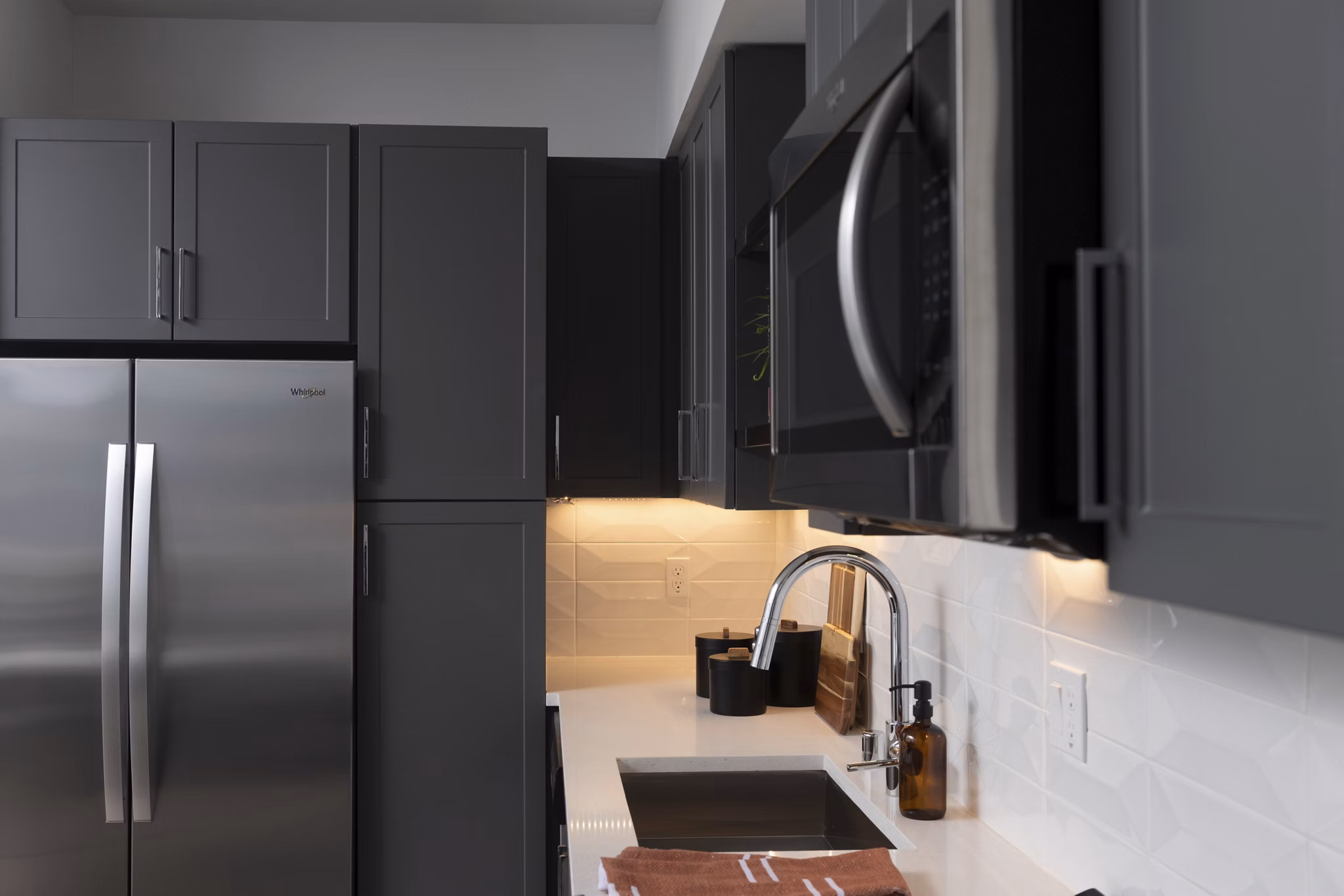 Modern kitchen with stainless steel appliances in The Eisley Apartments