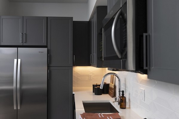 Modern kitchen with stainless steel appliances in The Eisley Apartments