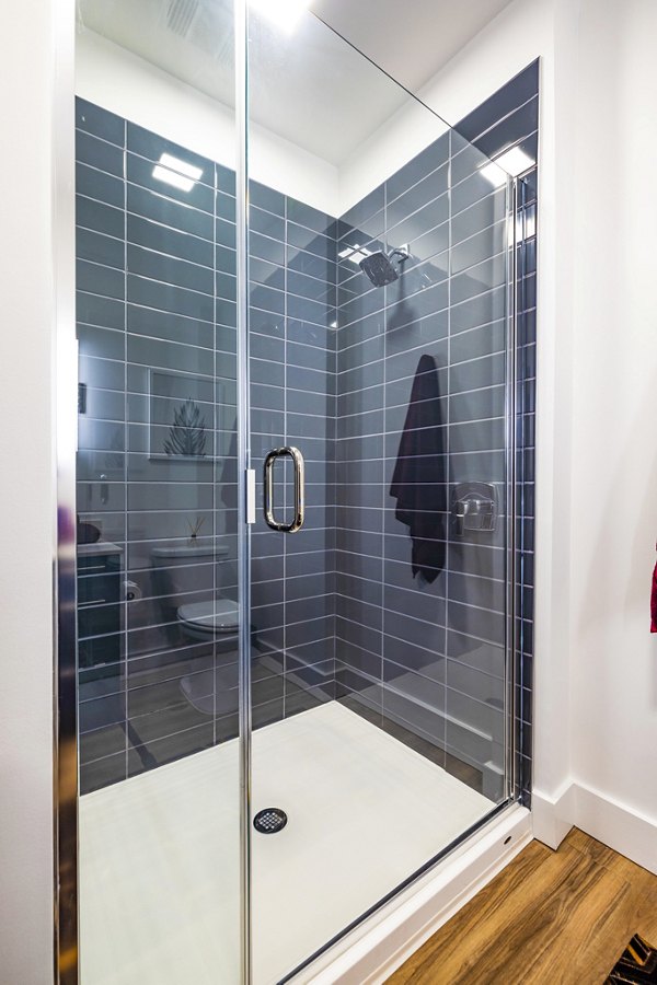Elegant bathroom with glass shower and modern fixtures at Novel Midtown Apartments