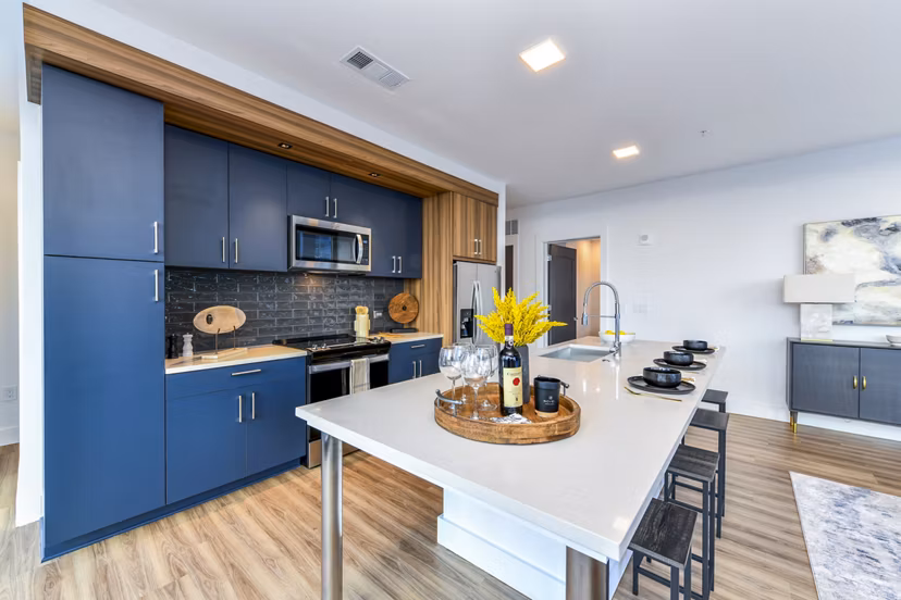 Modern kitchen with stainless steel appliances and marble countertops at Novel Midtown Apartments