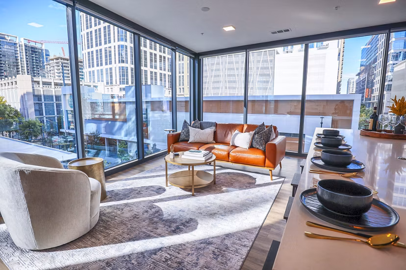Spacious living room with modern decor at Novel Midtown Apartments, featuring comfortable seating and stylish lighting