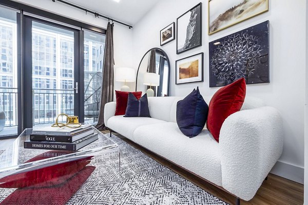 Spacious living room with modern decor at Novel Midtown Apartments, featuring large windows and stylish furniture
