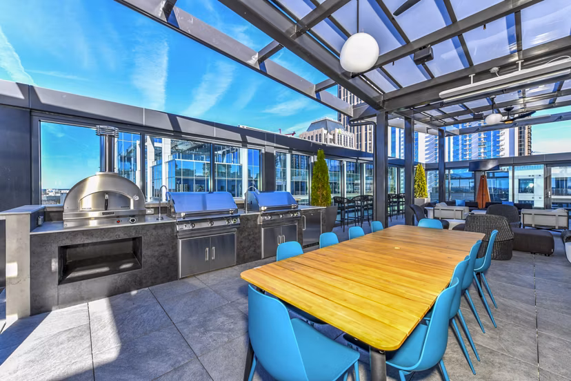 Outdoor grill area and patio at Novel Midtown Apartments featuring modern seating and lush greenery