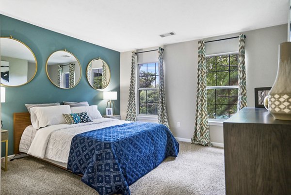 Peaceful bedroom with pastel decor and large windows in Bridgewater Apartments