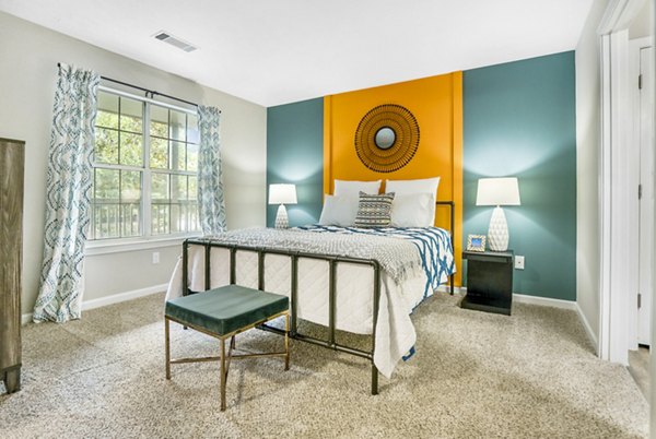 Cozy bedroom with modern decor at Bridgewater Apartments, featuring plush bedding and large windows for natural light