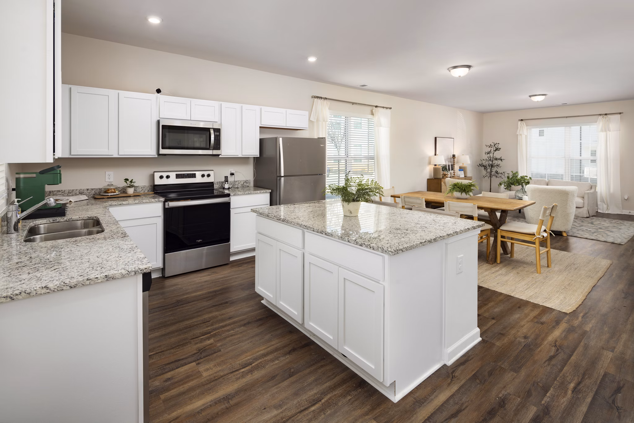 Modern kitchen with granite countertops and stainless steel appliances in Townes at Hamilton Apartments