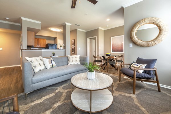 Spacious living room with modern decor in Olympus Team Ranch Apartments, featuring a comfortable seating area and large windows