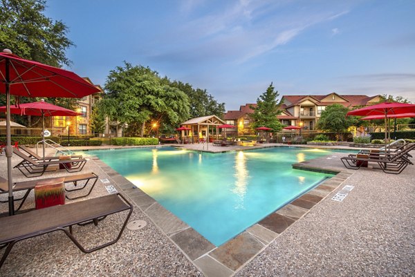 Resort-style pool with lounge chairs at Olympus Team Ranch Apartments offering luxury living experience