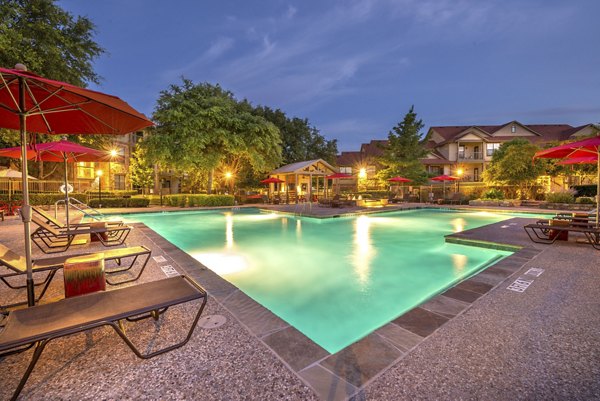 Resort-style pool with lounging area at Olympus Team Ranch Apartments