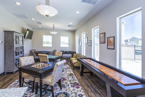 Clubhouse game room with billiards and lounge seating at Retreat at Patriot Park Apartments