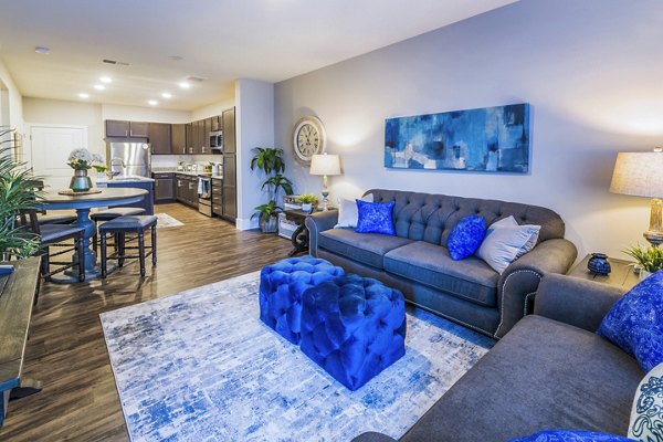 Spacious living room with modern decor and ample natural light in Retreat at Patriot Park Apartments, offering Greystar luxury living