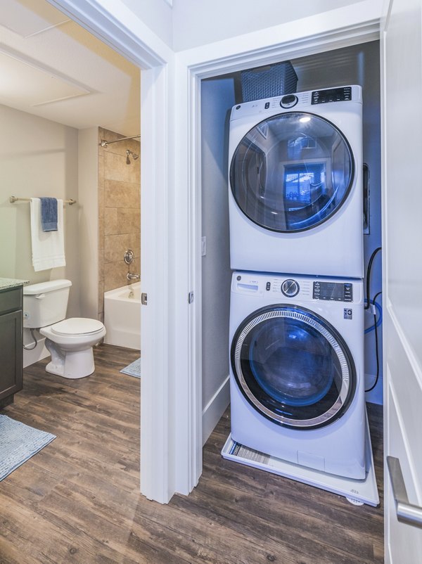 Laundry room with modern machines at Retreat at Patriot Park luxury apartments