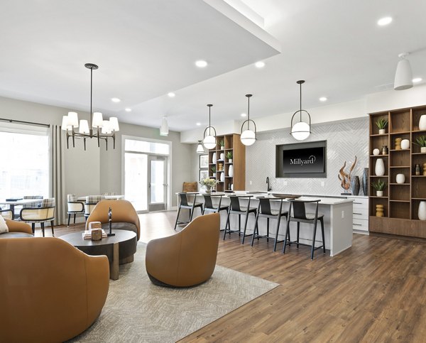 Clubhouse at Millyard at Meadow Commons Apartments: Modern design with cozy seating and a fireplace