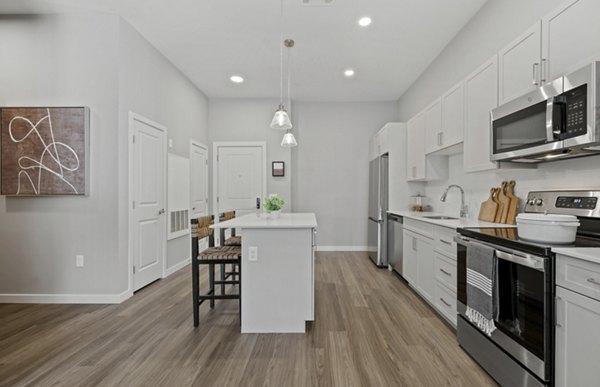 Modern kitchen with sleek countertops and stainless steel appliances at Millyard at Meadow Commons Apartments