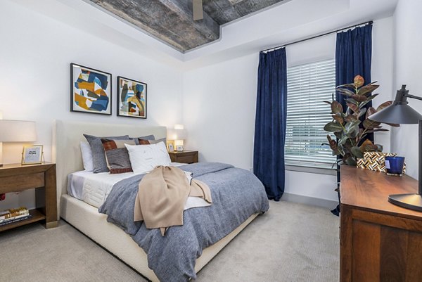 Elegant master bedroom with contemporary furnishings at The Premier Apartments