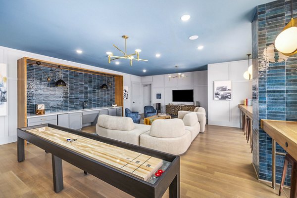Clubhouse game room featuring billiards table and lounge seating at The Premier Apartments