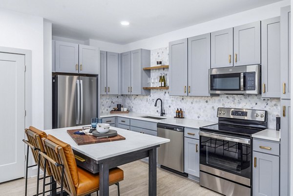 Modern kitchen featuring stainless steel appliances and granite countertops at The Premier Apartments