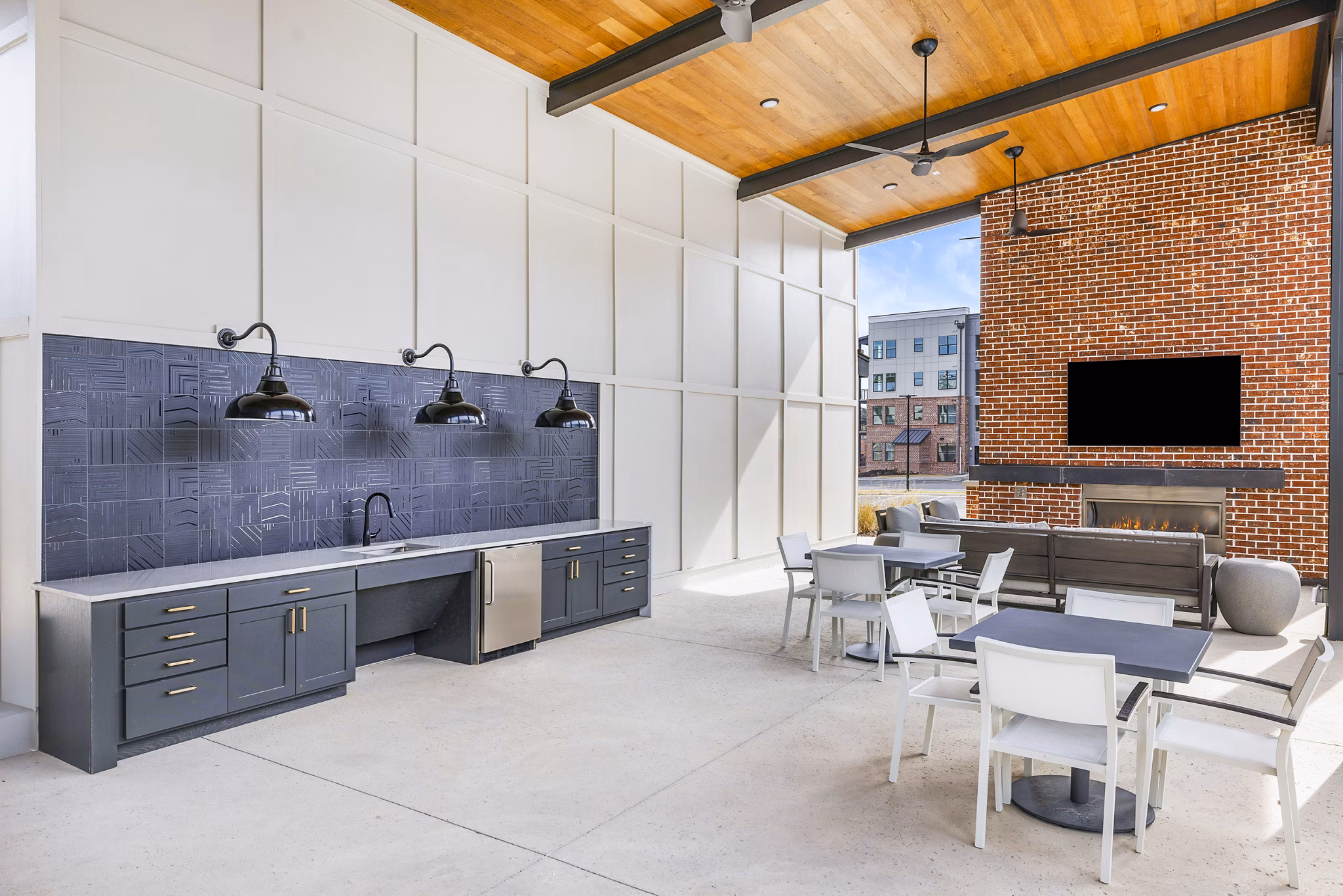 Outdoor grill area and patio at The Premier Apartments, perfect for social gatherings and relaxation amidst lush landscaping