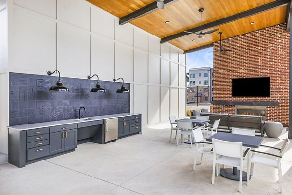 Outdoor grill area and patio at The Premier Apartments, perfect for social gatherings and relaxation amidst lush landscaping
