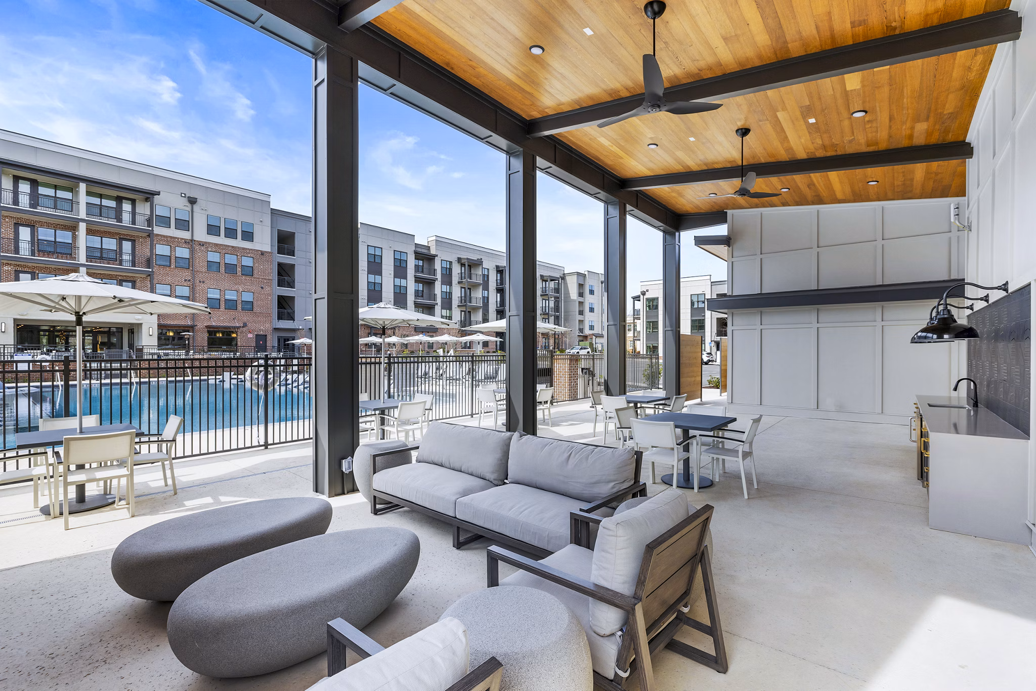 Outdoor grill area and patio at The Premier Apartments with lush landscaping