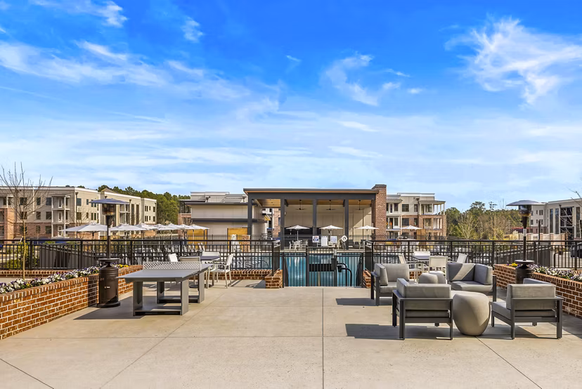 Patio featuring cozy seating and lush greenery at The Premier Apartments