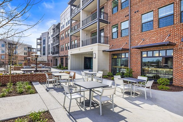Outdoor grill area and patio with seating at The Premier Apartments, ideal for social gatherings and relaxation