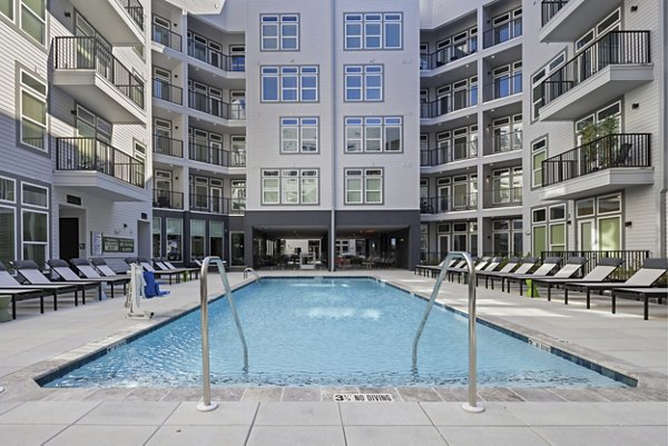 Resort-style pool at Mira Raleigh Apartments offering luxury lounging and sunbathing spaces