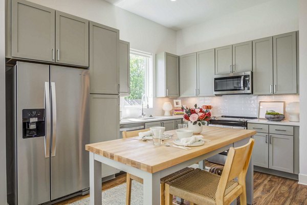 Modern kitchen with stainless steel appliances at Queens Wedgewood Houston Apartments