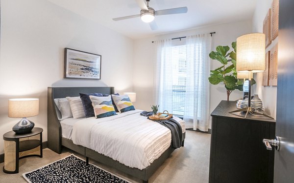 Bedroom with plush bedding and designer decor at The Sommery Apartments, a luxury community offering refined comfort and style