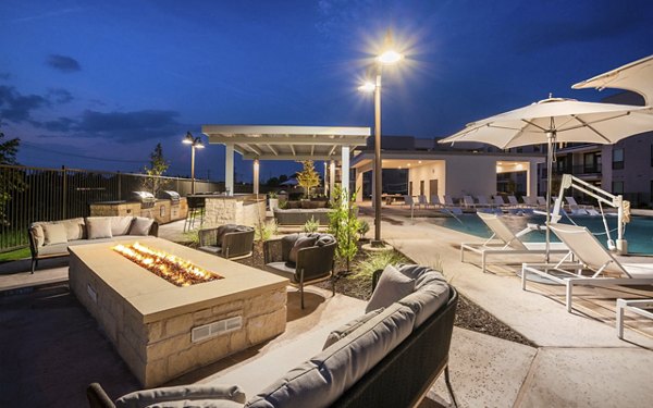 Cozy evening fire pit area at The Sommery Apartments with seating under string lights, ideal for gathering and relaxation
