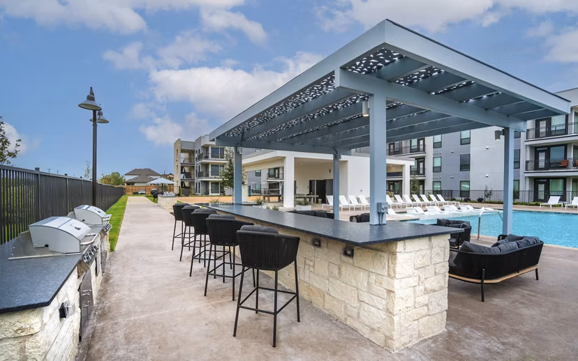 Outdoor grill area with modern seating at The Sommery Apartments