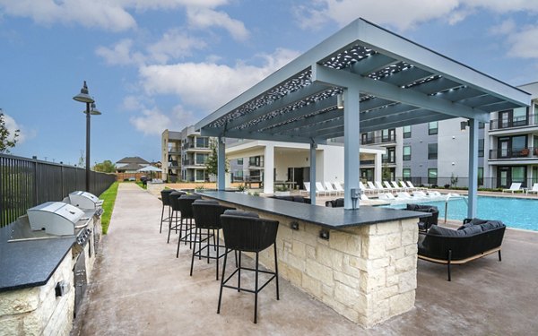 Outdoor grill area with modern seating at The Sommery Apartments