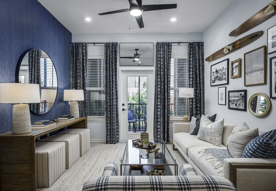 Spacious living room with modern furnishings and large windows in The Elliott Apartments