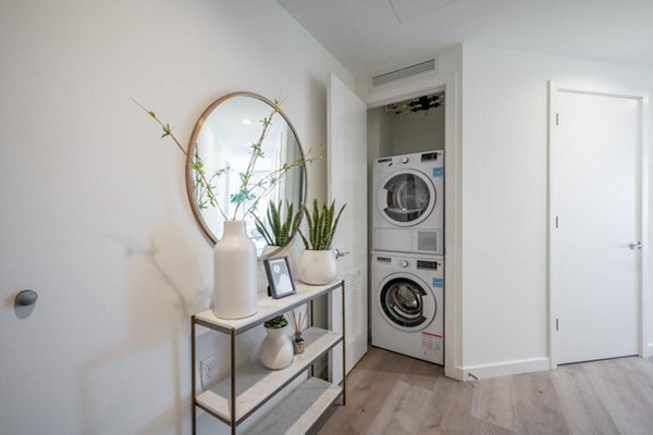 Laundry room with modern washers and dryers at Collection 14 Apartments in vibrant urban environment
