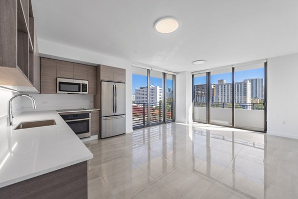 Spacious living room with modern decor and large windows in The Vibe Miami Apartments