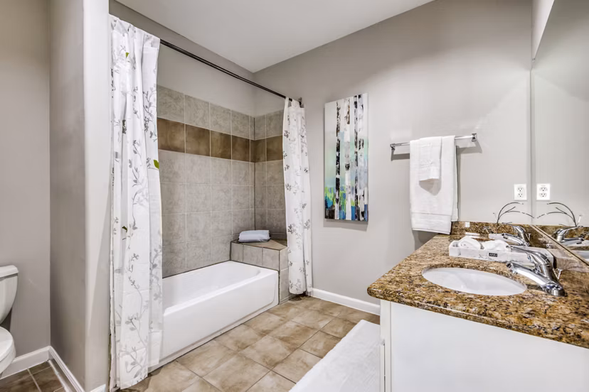 Bathroom with modern fixtures and granite countertops at Addicks Stone Village Apartments
