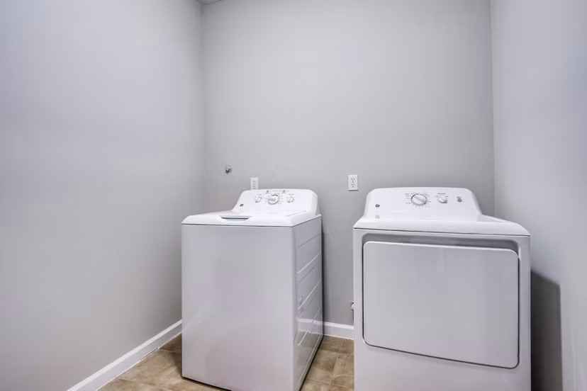 Laundry room with energy-efficient washers and dryers at Addicks Stone Village Apartments